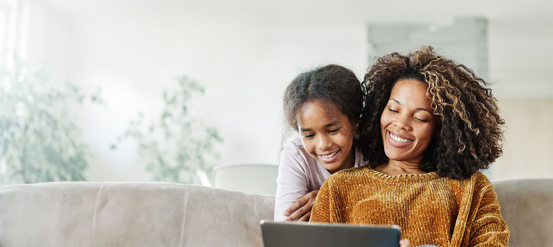 Smiling daughter and Mom looking at laptop