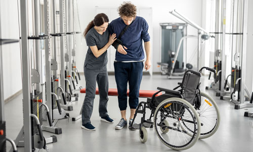 Woman holds man up who is wearing an arm brace.